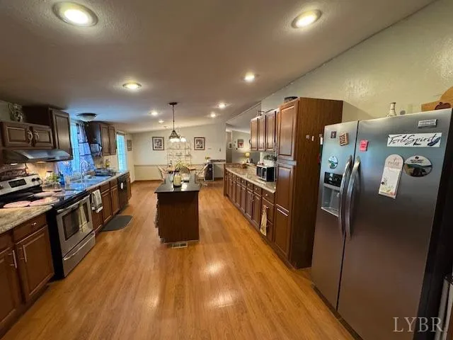 a kitchen with stainless steel appliances a refrigerator a stove a sink a microwave and cabinets
