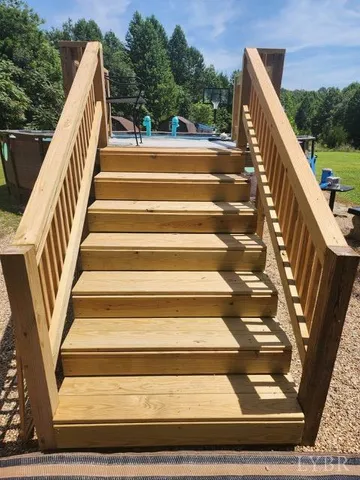 a view of a table and chairs in backyard under a large tree
