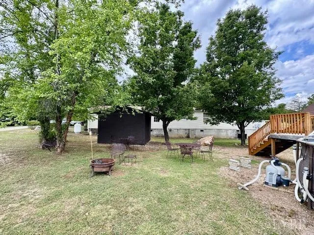 a view of a backyard with table and chairs and a fire pit