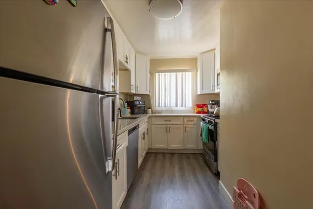 a kitchen with a refrigerator a sink and cabinets