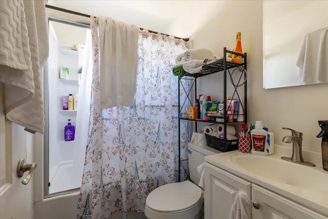 a bathroom with a sink a toilet and shower curtain