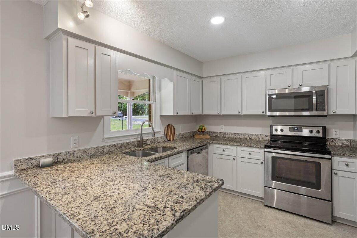 805 Rand Road Garner, NC 27529 - Photo 24 of 38 a kitchen with a sink stove and microwave