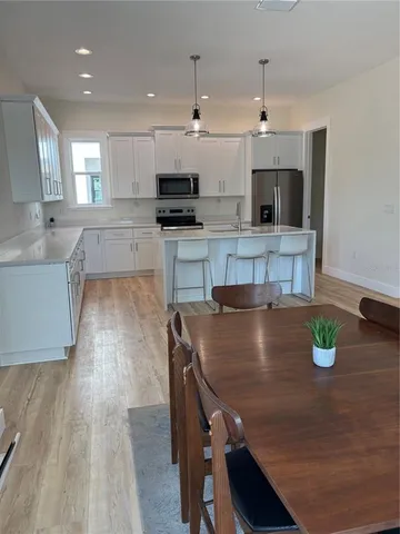 a kitchen with a dining table chairs and appliances