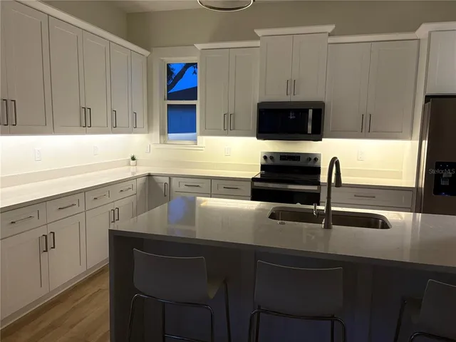a kitchen with white cabinets and stainless steel appliances