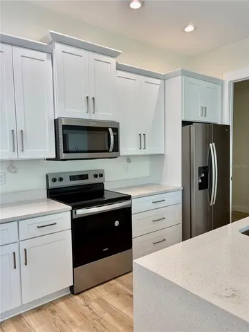 a kitchen with sink cabinets and chandelier