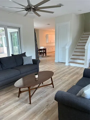 a kitchen with stainless steel appliances granite countertop a stove top oven a sink dishwasher a dining table and chairs with wooden floor