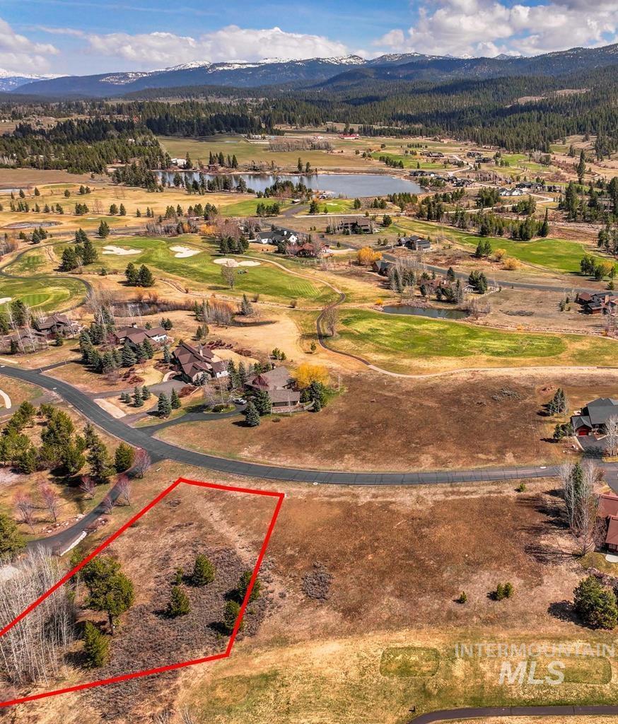 Aerial overview of property's location with property boundaries highlighted, a water and mountain view, and a golf course