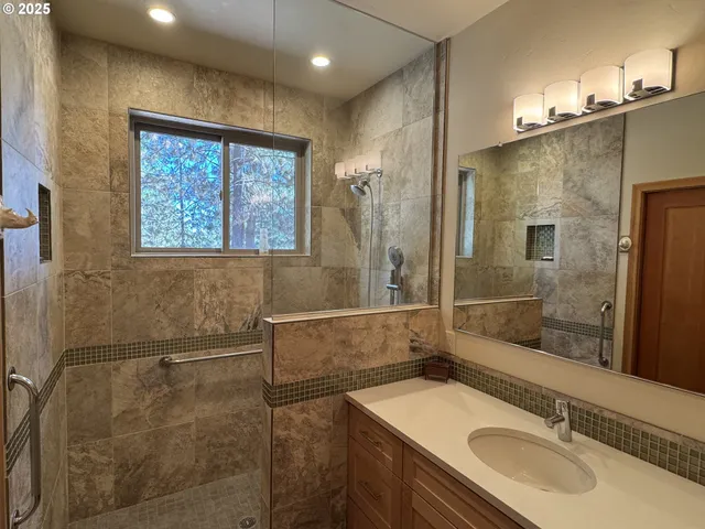 a bathroom with a sink shower and a mirror