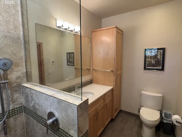 a bathroom with a sink a toilet and shower
