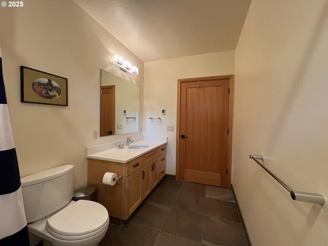 a bathroom with a granite countertop toilet sink and mirror