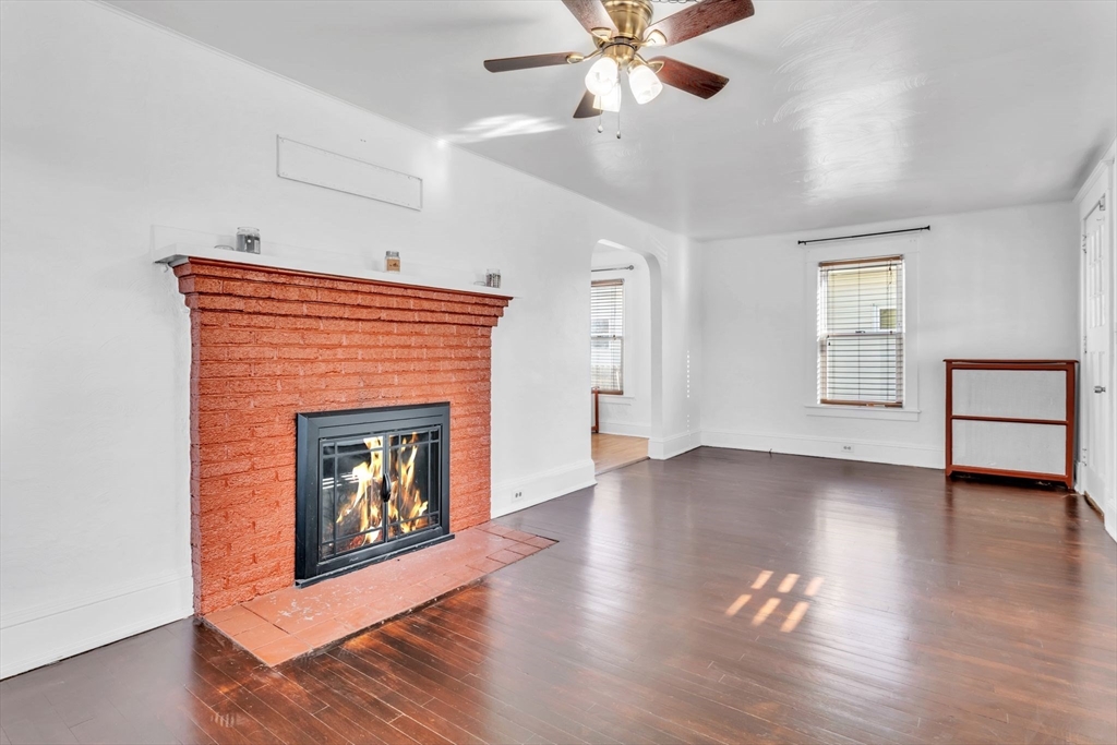 164 Phoenix Terrace Springfield, MA 01104 - Photo 4 of 39 a view of an empty room with wooden floor fireplace and a window