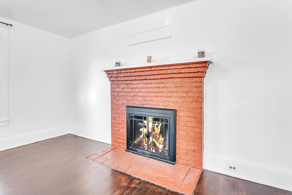 164 Phoenix Terrace Springfield, MA 01104 - Photo 5 of 39 a view of an empty room with wooden floor and a fireplace