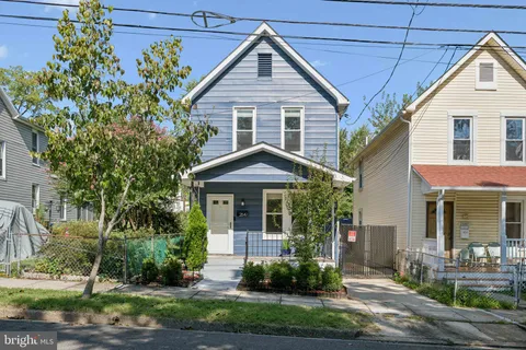 a front view of a house with a yard and potted plants