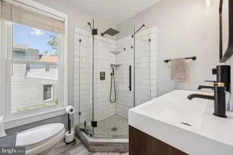 a bathroom with a sink a toilet and shower
