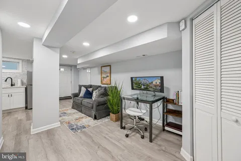 a living room with furniture a wooden floor and a large window