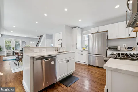 a kitchen with kitchen island a white cabinets and wooden floor