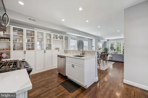 a kitchen with sink cabinets and wooden floor