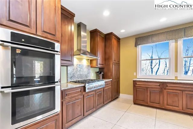 a kitchen with stainless steel appliances granite countertop a refrigerator and a stove top oven
