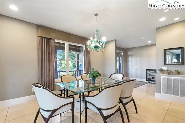 a dining room with furniture a chandelier and wooden floor