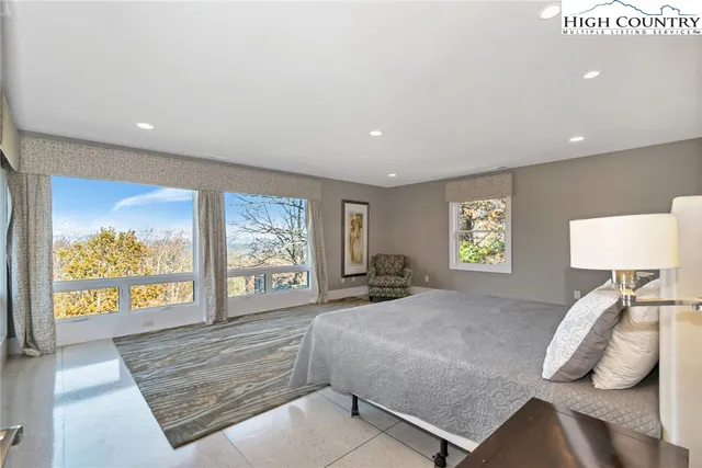 a bedroom with a bed and a large window