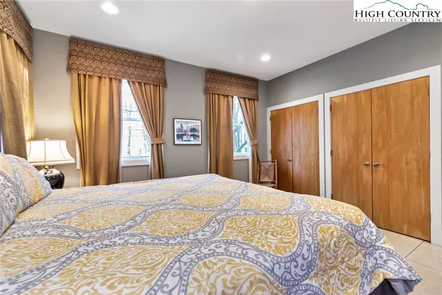 a bedroom with a large bed and a large mirror