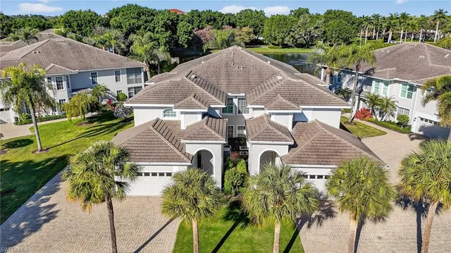 a aerial view of a house with a yard and palm trees