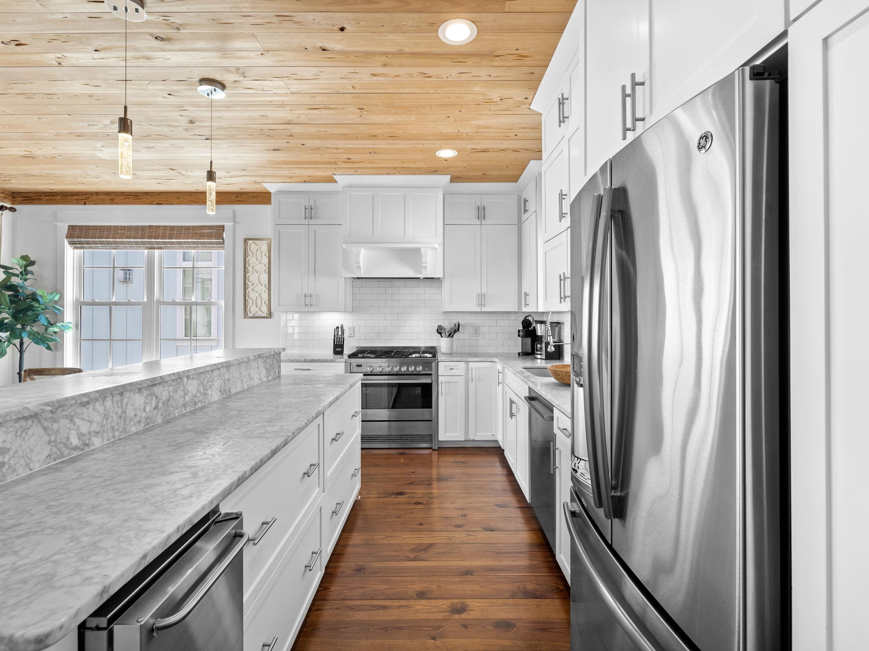 113 Dunes Estates Boulevard Santa Rosa Beach, FL 32459 - Photo 16 of 35 a kitchen with white cabinets and stainless steel appliances