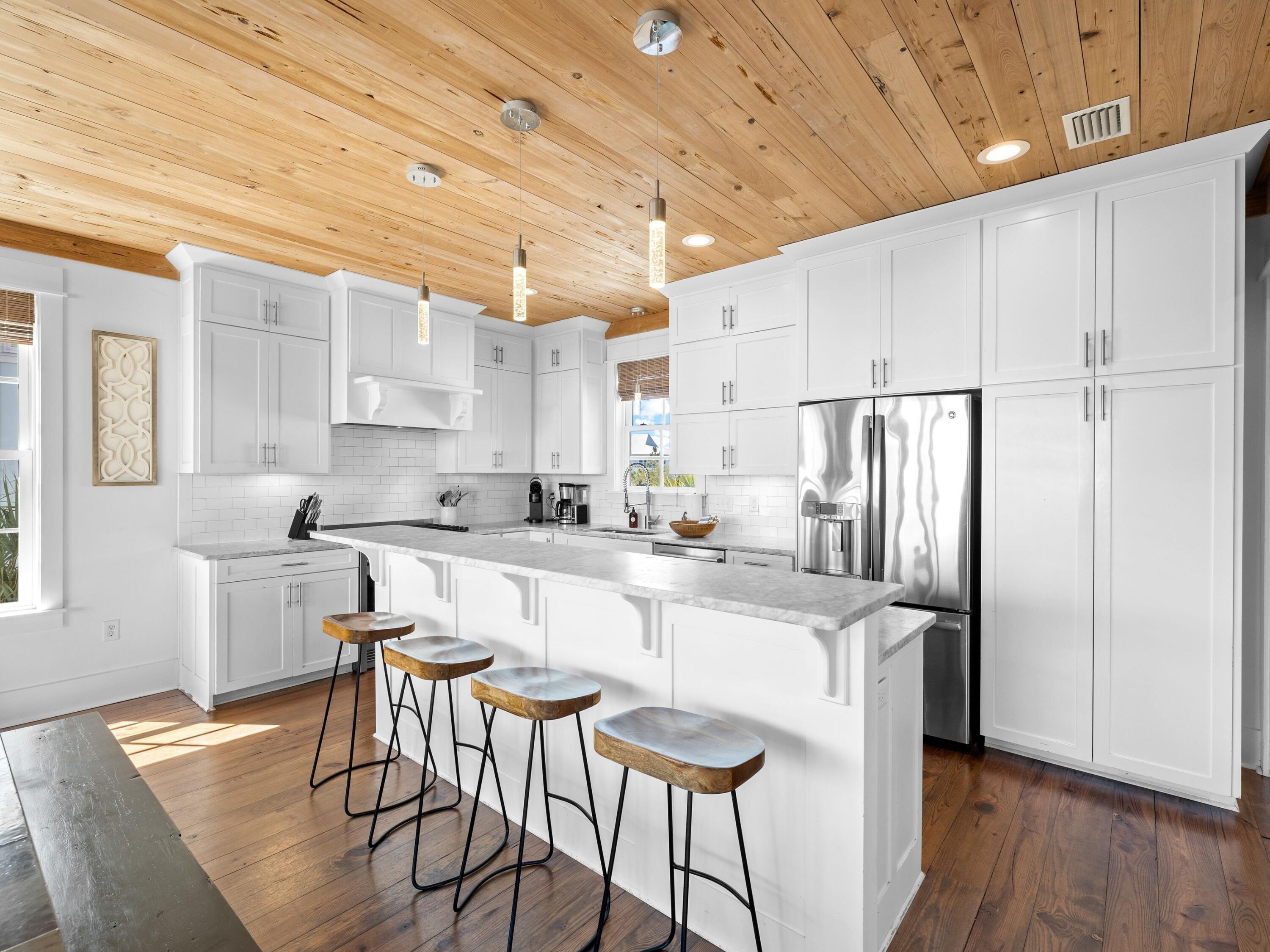 113 Dunes Estates Boulevard Santa Rosa Beach, FL 32459 - Photo 5 of 35 a kitchen with stainless steel appliances a refrigerator a stove a sink dishwasher and white cabinets with wooden floor