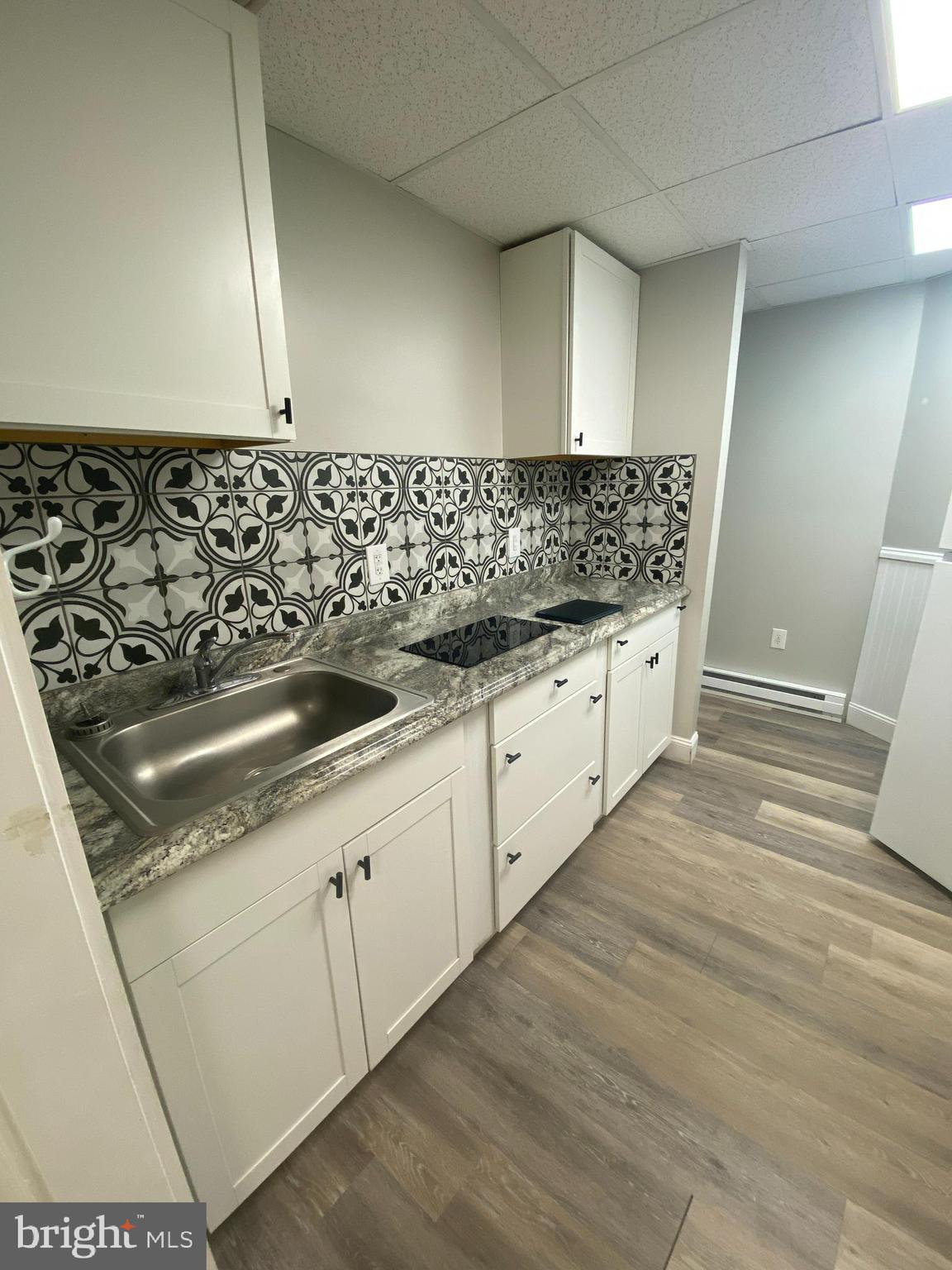 53 Gilmore Street, Unit A Keyser, WV 26726 - Photo 2 of 9 a kitchen with granite countertop white cabinets and a sink