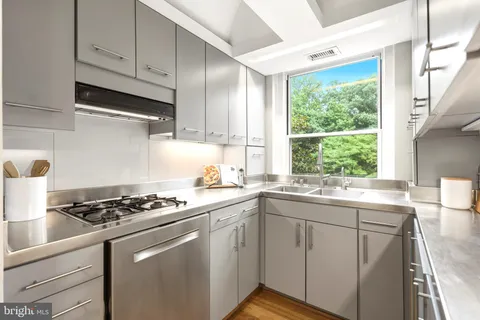 a kitchen with stainless steel appliances granite countertop a sink a stove and cabinets
