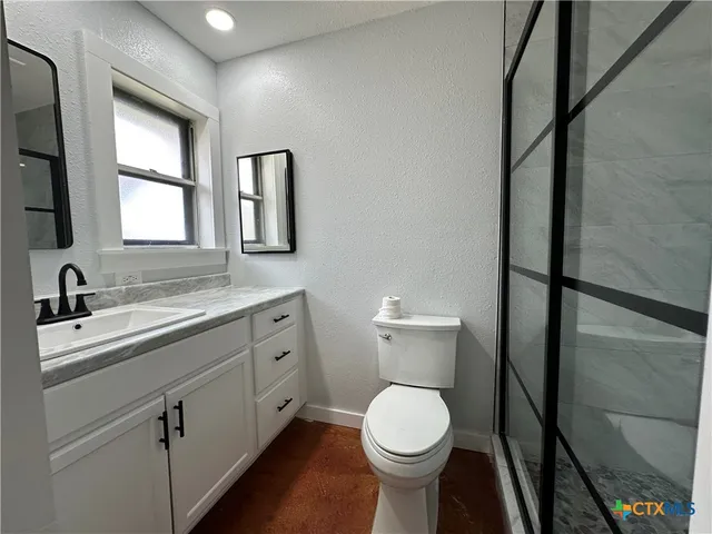 a white toilet sitting next to a shower