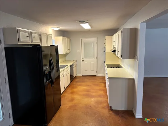 a kitchen with a refrigerator and a sink