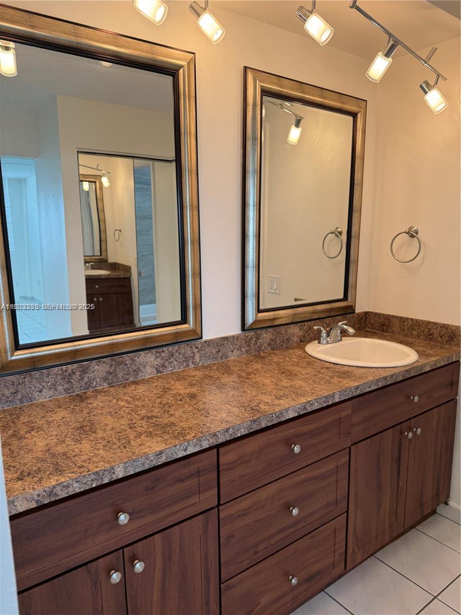14250 Southwest 62nd Street, Unit 524 Miami, FL 33183 - Photo 21 of 27 a bathroom with a granite countertop sink and a mirror