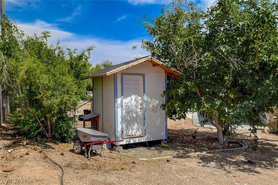 4362 Thistle Street Logandale, NV 89021 - Photo 93 of 99 A quaint outbuilding offers additional storage amidst established backyard greenery.