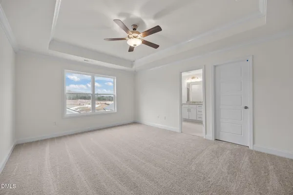 a view of an empty room with chandelier fan