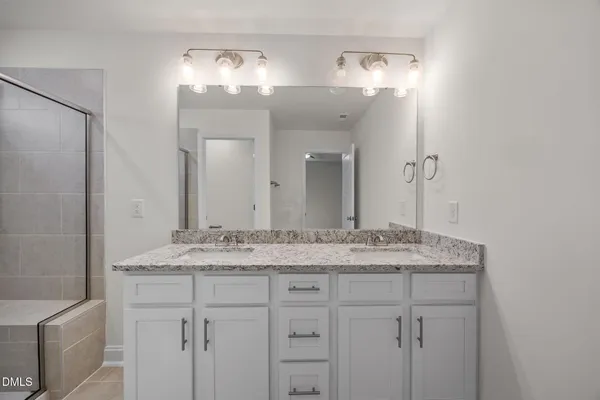 a bathroom with a granite countertop shower a toilet and a sink