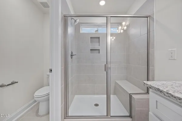 a bathroom with a granite countertop sink a mirror and a shower