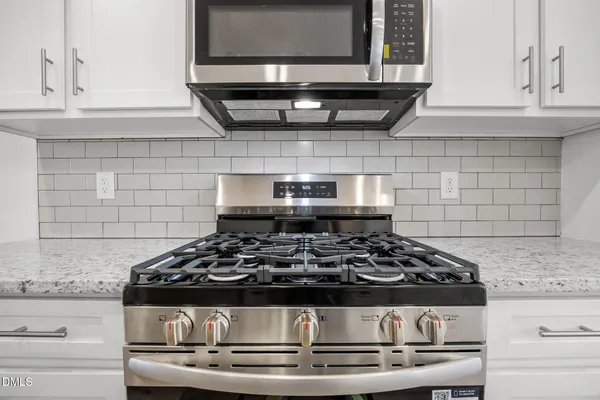 a kitchen with stainless steel appliances granite countertop a sink and a microwave