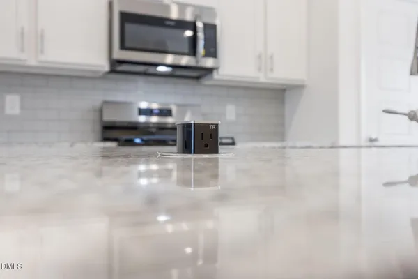 a kitchen with granite countertop a stove top oven sink and cabinets