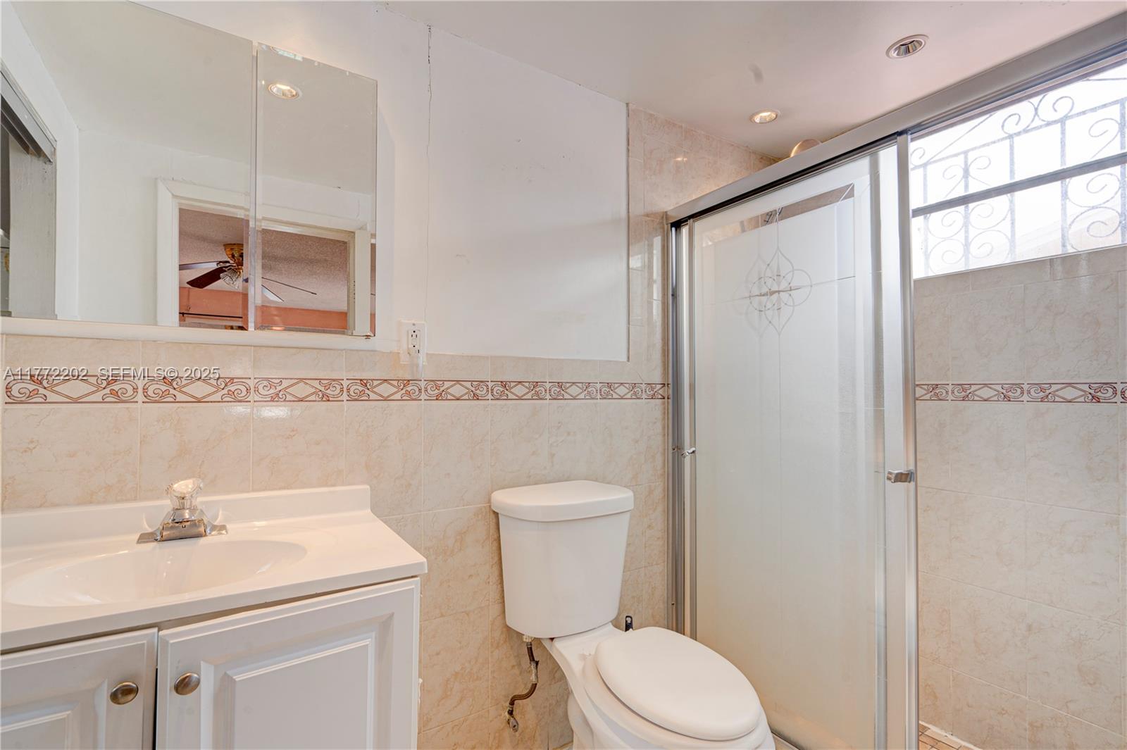390 East 44th Street Hialeah, FL 33013 - Photo 12 of 39 a bathroom with a toilet a sink and a mirror