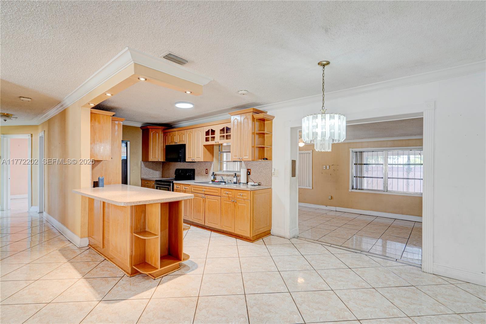 390 East 44th Street Hialeah, FL 33013 - Photo 3 of 39 a large kitchen with kitchen island granite countertop a refrigerator a oven a counter top space and wooden floor