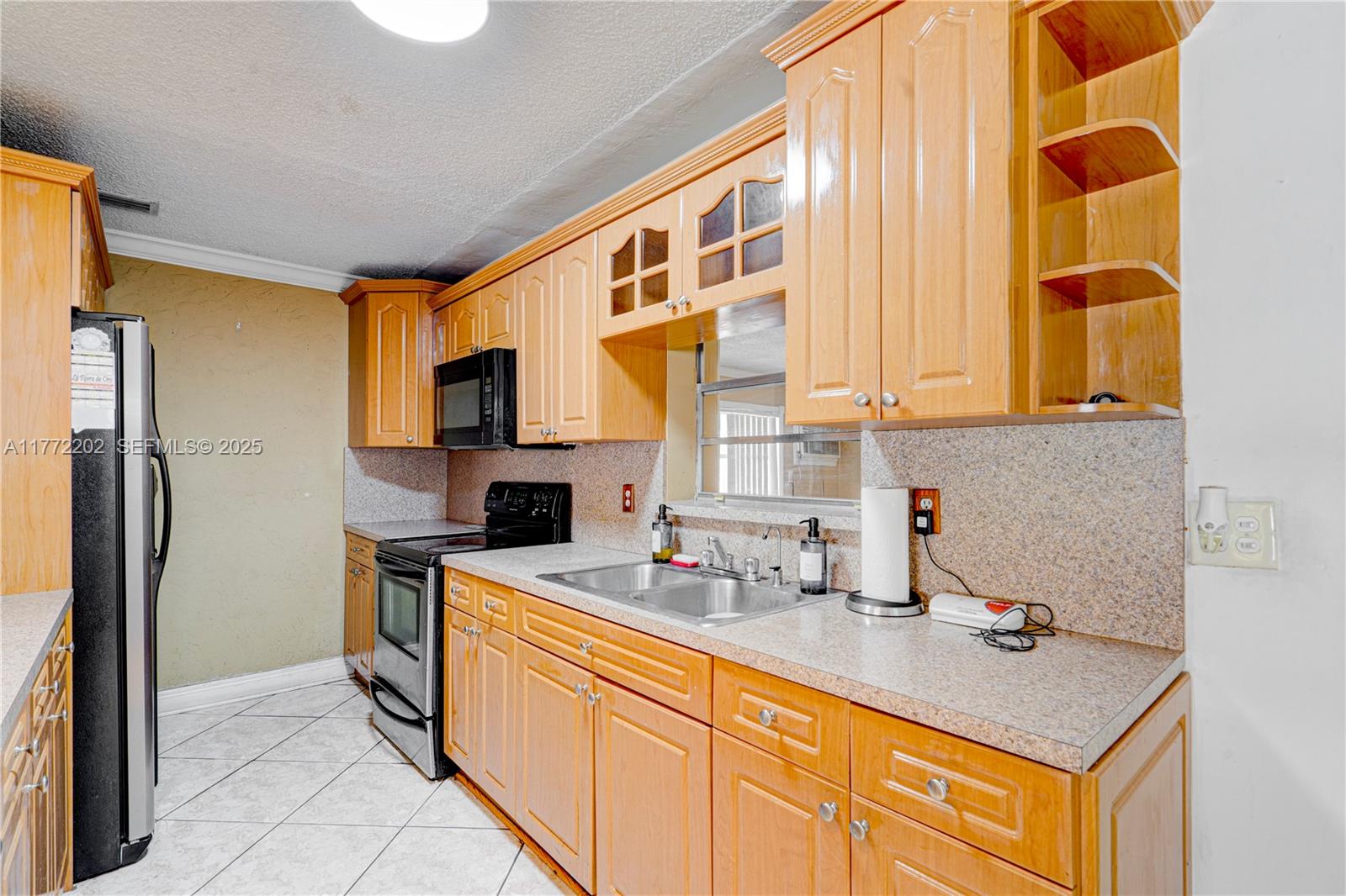 390 East 44th Street Hialeah, FL 33013 - Photo 7 of 39 a kitchen with stainless steel appliances a sink stove and refrigerator