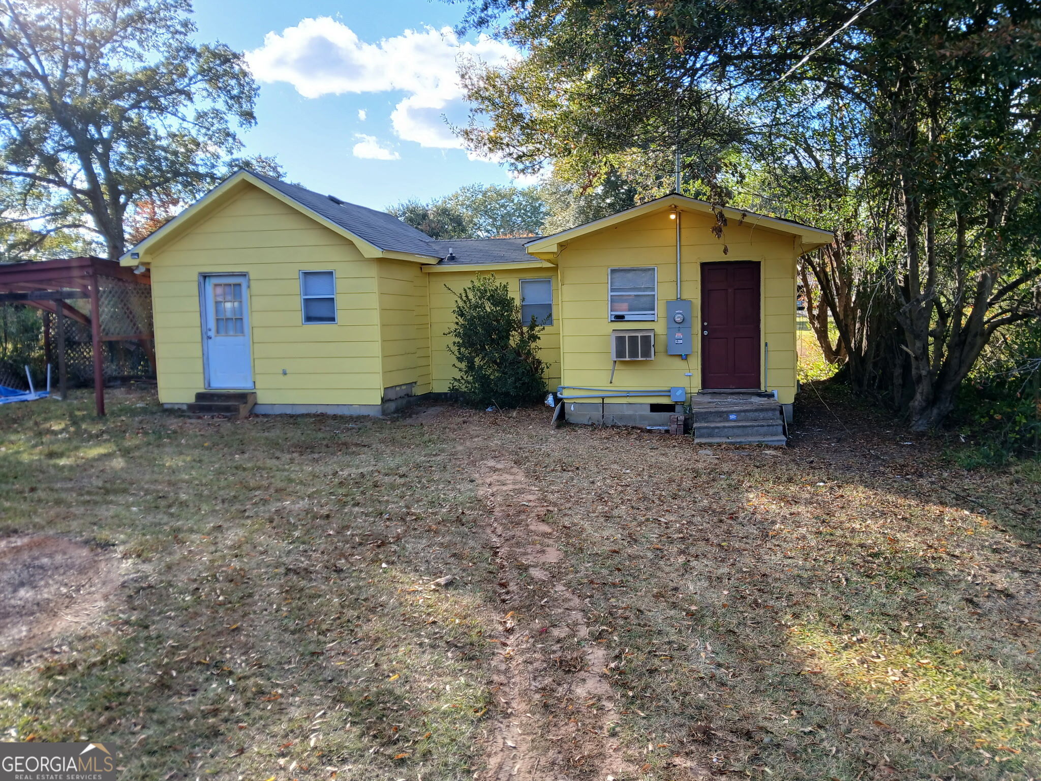 a view of backyard of house with wooden fence