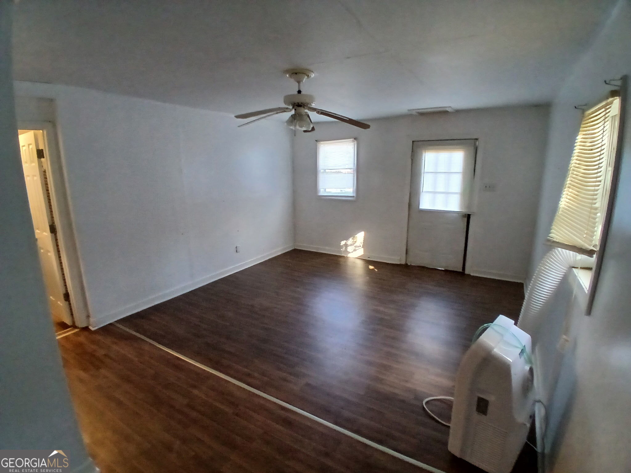 218 A Hunt Street Fort Valley, GA 31030 - Photo 3 of 8 wooden floor in an empty room with a window