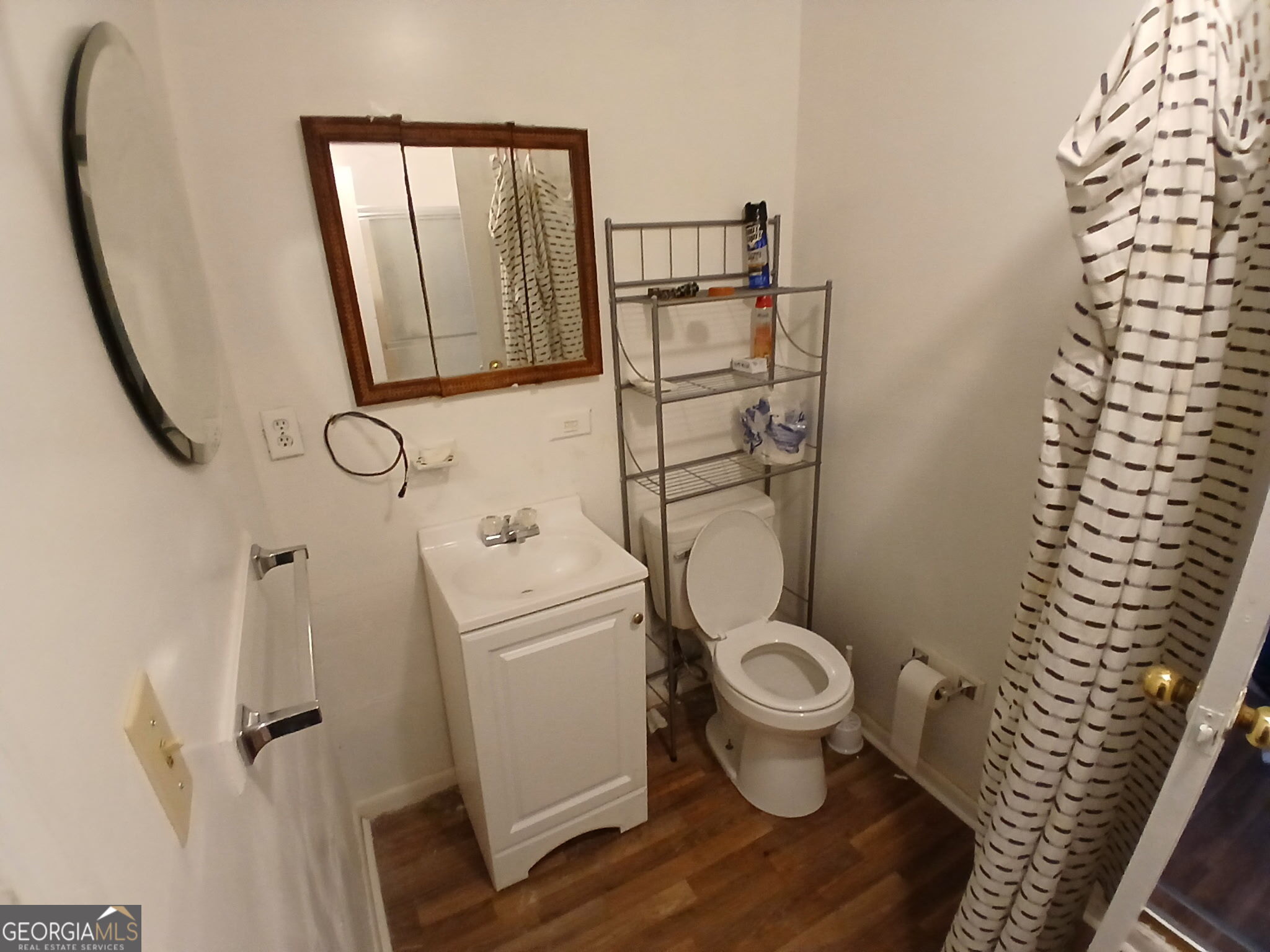 218 A Hunt Street Fort Valley, GA 31030 - Photo 7 of 8 a white toilet sitting next to a bathroom sink and a mirror