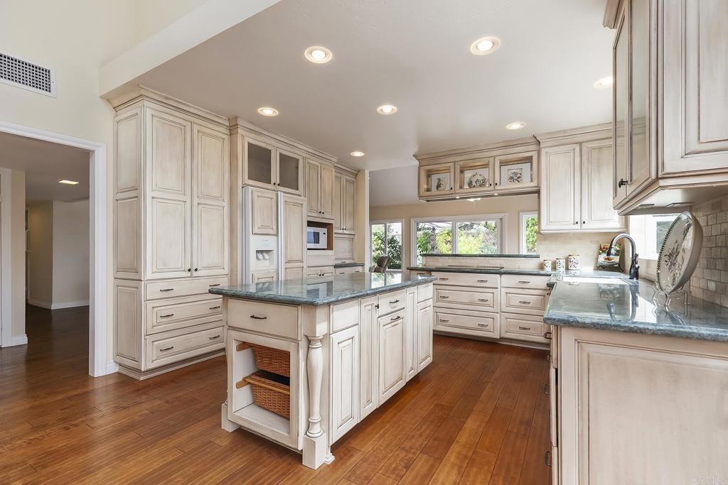 747 Santa Victoria Solana Beach, CA 92075 - Photo 20 of 57 a kitchen with stainless steel appliances sink cabinets and wooden floor