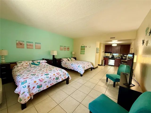 a bedroom with two beds and a chair