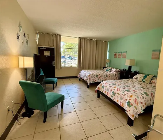 a bedroom with two beds and a mirror