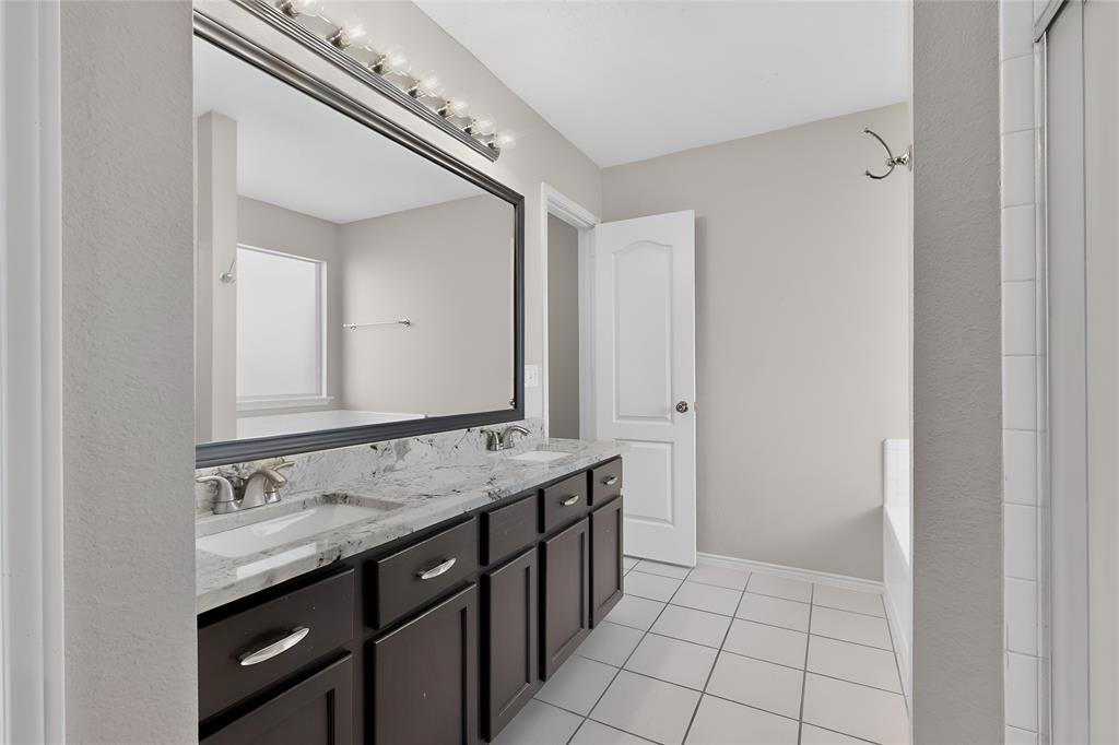 1207 Aberdeen Drive Allen, TX 75002 - Photo 27 of 40 a bathroom with a granite countertop sink a vanity and a mirror