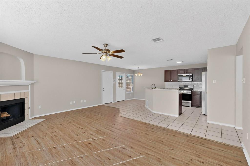 1207 Aberdeen Drive Allen, TX 75002 - Photo 8 of 40 a view of a kitchen with wooden floor and a fireplace